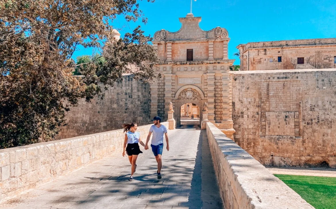 couple marchant près des portes de Mdina