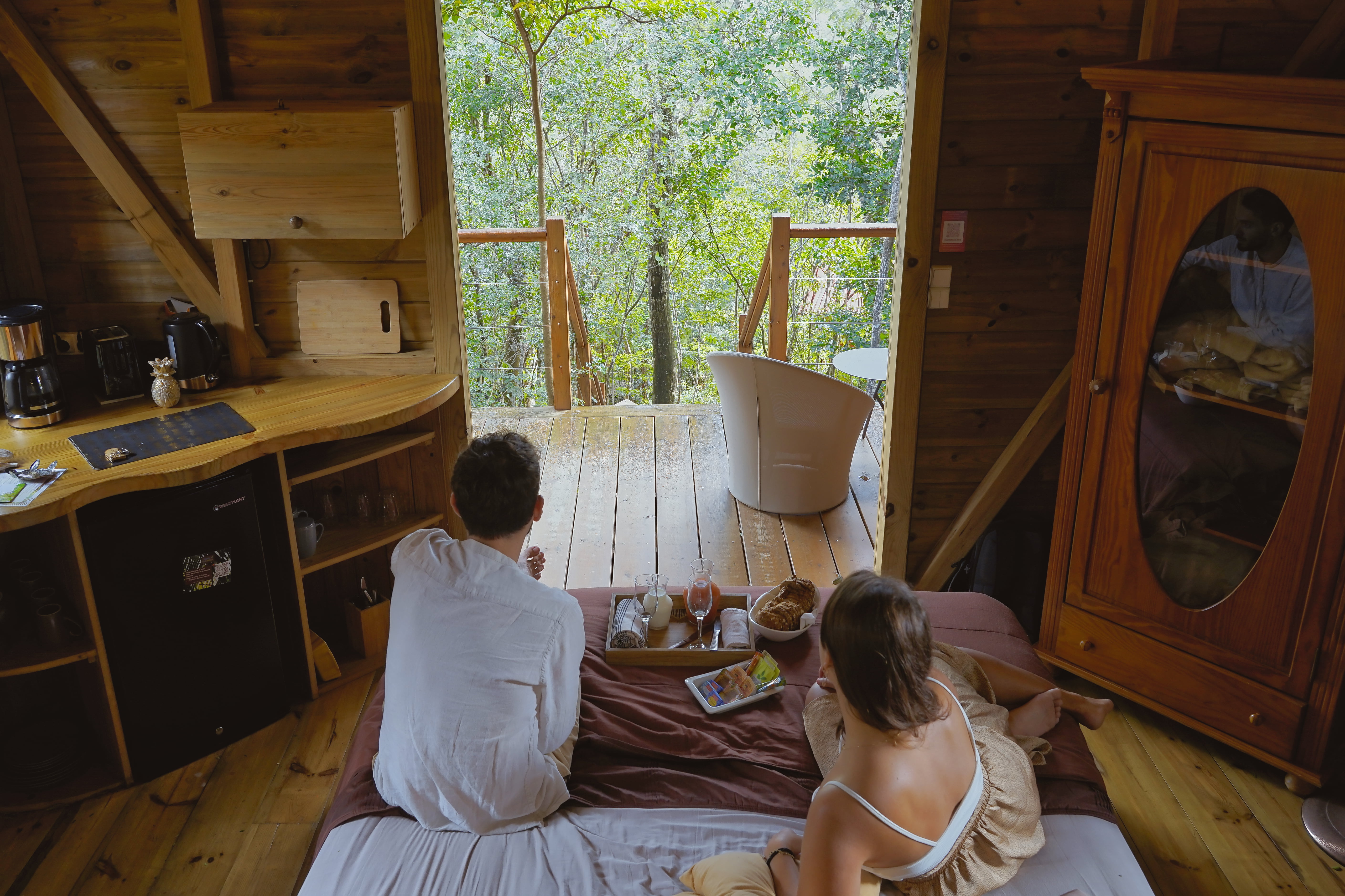 couple sur le lit prenant petit dejeuner dans une cabane insolite en guadeloupe